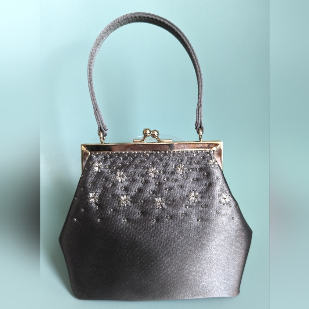 The Limited tiny bag in grey satin with silver accent embroidery.